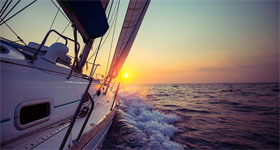 Een boot vaart over zee richting de ondergaande zon - Reditus Advies financiele planning